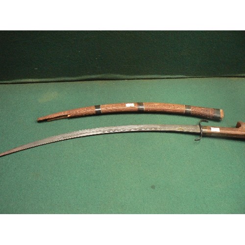 202 - A vintage Moroccan short sword. The blade with chiseled decoration -iron guard and shaped wooden hil... 