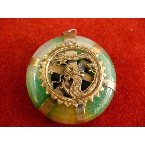 69 - Four 20th Century Chinese carved pendants including a jade buddha, a jade disc with brass dragon det... 