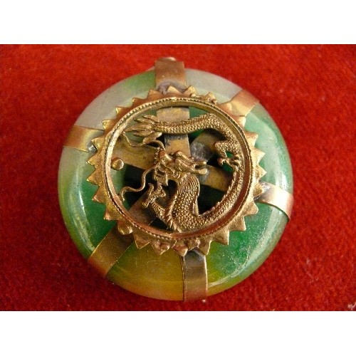 69 - Four 20th Century Chinese carved pendants including a jade buddha, a jade disc with brass dragon det... 