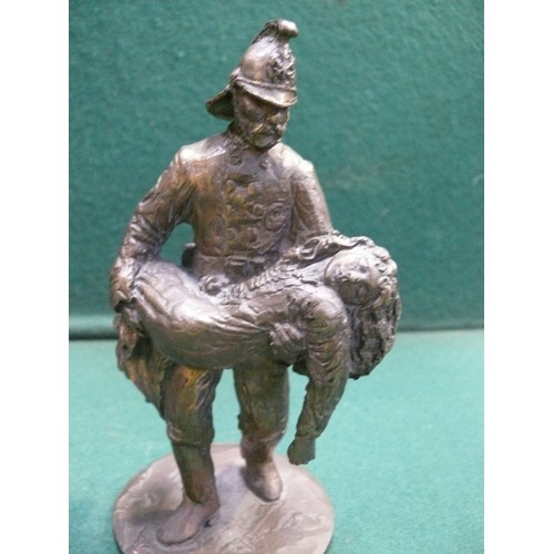 215 - A solid bronze figure of a fireman carrying a child. Well cast piece. Indistinct rubbed marks to the... 