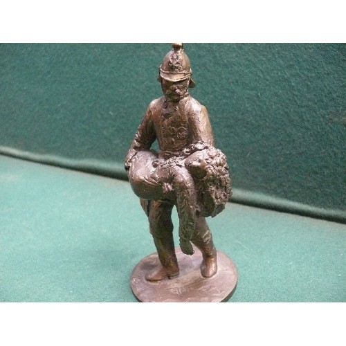 215 - A solid bronze figure of a fireman carrying a child. Well cast piece. Indistinct rubbed marks to the... 