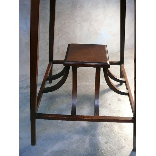 423 - An Edwardian side table with unusual curved supports for the shelf below