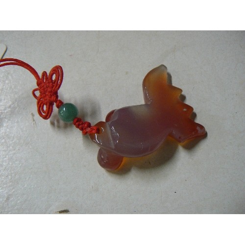 68 - An Oriental natural quartz stone fish on plaited toggle with jade bead and a sign of the zodiac pend... 