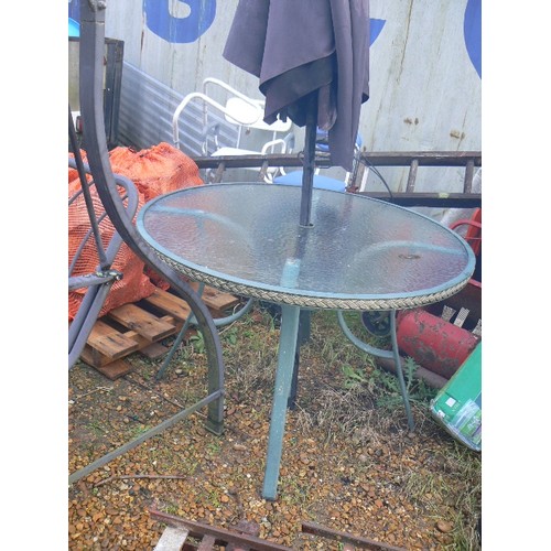 512 - ROUND GARDEN TABLE WITH GLASS TOP PLUS A LARGE BLACK PARASOL.