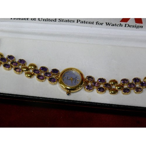 10A - MARCEL DRUCKER SIGNATURE LADIES WATCH  WITH PURPLE TOPAZ STYLE STONES IN BRACELET.