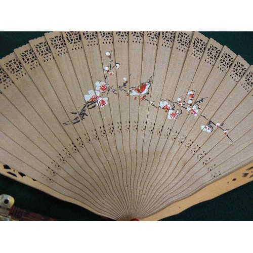 257 - TWO ORIENTAL HAND FANS AND BAODING BALLS IN A FABRIC COVERED BOX.