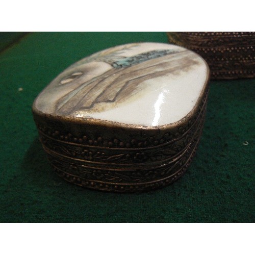 260 - THREE 20TH CENTURY ORIENTAL SILVER METAL TRINKET BOXES, THE TOPS WITH PORCELAIN INSERTS.