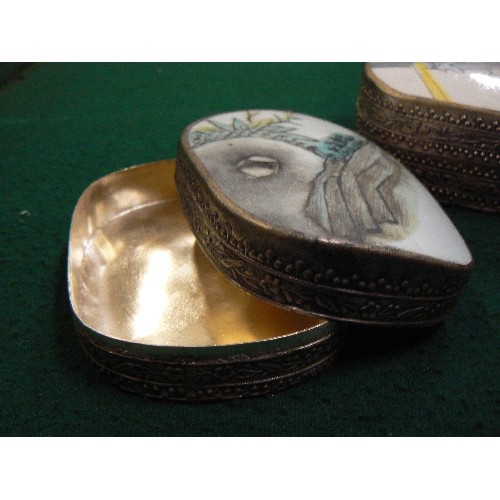 260 - THREE 20TH CENTURY ORIENTAL SILVER METAL TRINKET BOXES, THE TOPS WITH PORCELAIN INSERTS.