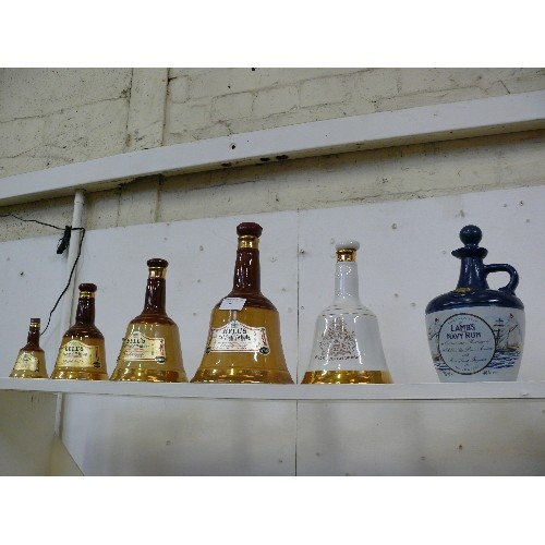 85 - A SET OF FIVE BELLS WHISKY DECANTERS PLUS A LAMBS NAVY RUM DECANTER.