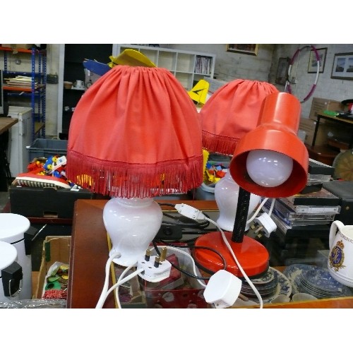 227 - A PAIR OF SMALL CERAMIC TABLE LAMPS WITH RED SHADES PLUS A RED DESK LAMP.