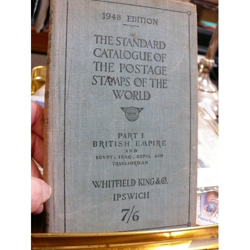 128 - TIN OF MIXED STAMPS AND 1948 EDITION THE STANDARD CATALOGUE OF THE POSTAGE STAMPS OF THE WORLD.