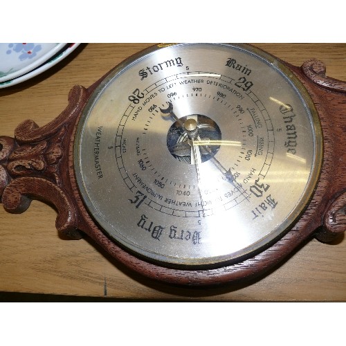 324 - A VINTAGE CARVED OAK WALL BAROMETER.