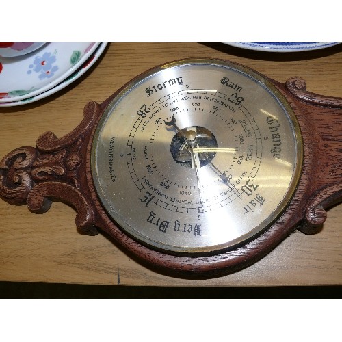 324 - A VINTAGE CARVED OAK WALL BAROMETER.