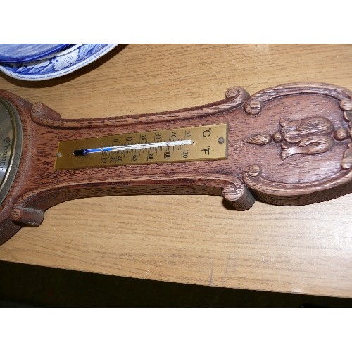 324 - A VINTAGE CARVED OAK WALL BAROMETER.