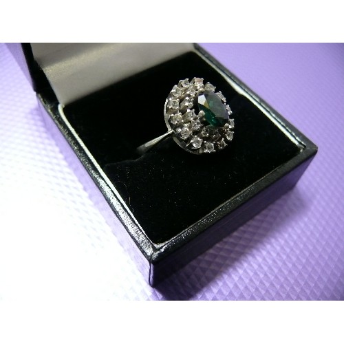 46 - A VINTAGE WHITE METAL DRESS RING SET WITH A CENTRAL FAUX EMERALD SURROUNDED BY DIAMANTE.