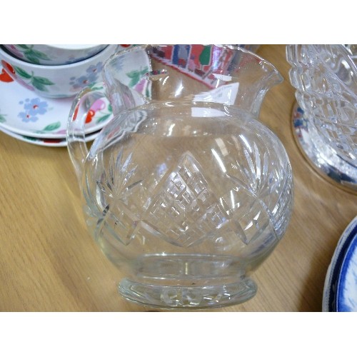 325 - A LARGE VINTAGE MOULDED GLASS FRUIT BOWL ON PLATED STAND AND A CUT GLASS WATER JUG.