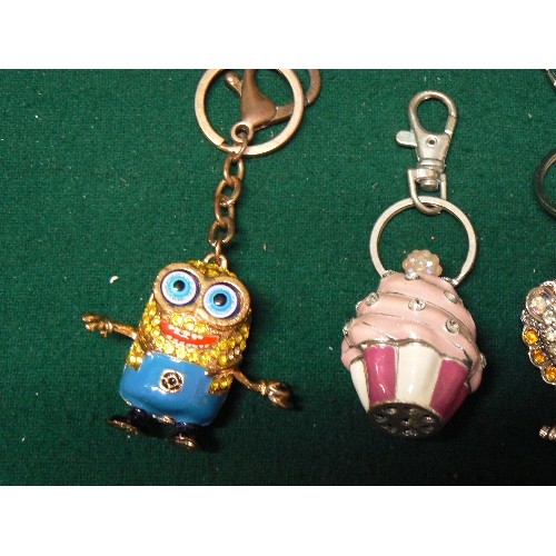 46 - FOUR NOVELTY KEY RINGS ENCRUSTED IN BLINGY STONES -  CAMERA, LION, CUP CAKE, PLUS ONE OTHER.