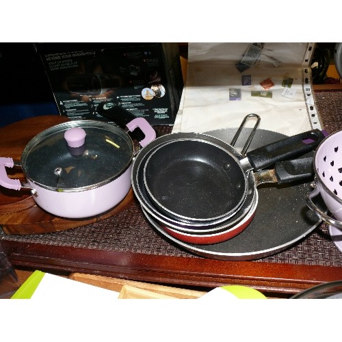 311 - A SMALL PINK SAUCEPAN AND MATCHING COLANDER PLUS THREE SMALL FRYING PANS.