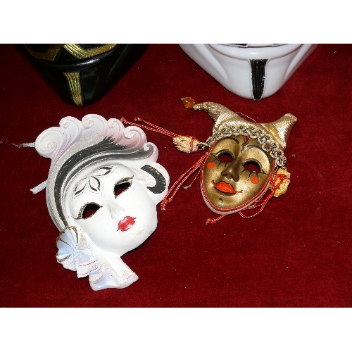 308 - TWO CERAMIC DECORATIVE VENETIAN MASKS PLUS A PAIR OF LARGER MASKS.