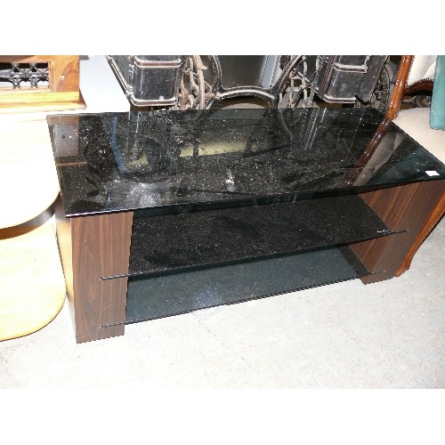 423 - CONTEMPORARY TV STAND WITH  DARK WOOD SIDES AND BLACK GLASS SHELVES.