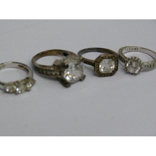 40E - FOUR SILVER METAL DRESS RINGS.