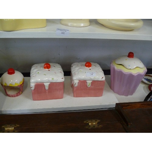 104 - THREE DECORATIVE CAKE STORAGE JARS PLUS A MATCHING CANDLE HOLDER.