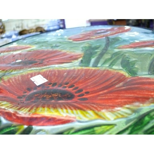 322 - A PAINTED GLASS TOPPED FOLDING TABLE DECORATED WITH POPPIES.