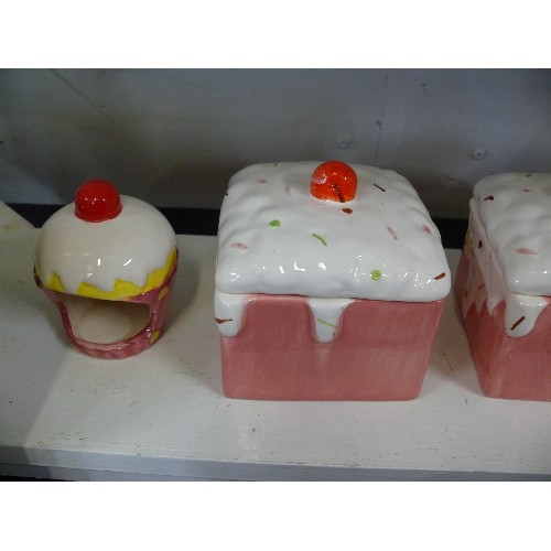 104 - THREE DECORATIVE CAKE STORAGE JARS PLUS A MATCHING CANDLE HOLDER.