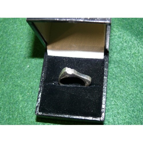 9 - SILVER UNUSUALLY SHAPED RING WITH A SINGLE STONE SET AT THE SIDE.