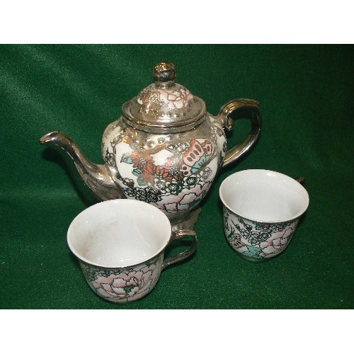 85 - A SILVER COLOURED TEAPOT WITH A MATCHING PAIR OF CUPS.