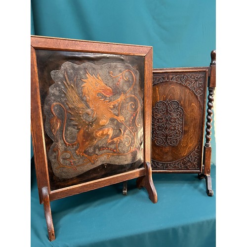 327A - Two 1920's /30's oak framed fire screens, one with embossed leather heraldic panel depicting a griff... 