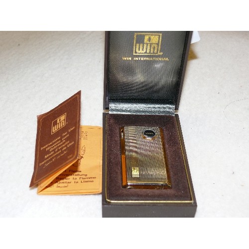 15 - A WIN INTERNATIONAL GOLD PLATED CIGARETTE LIGHTER WITH ORIGINAL BOX AND PAPERWORK.