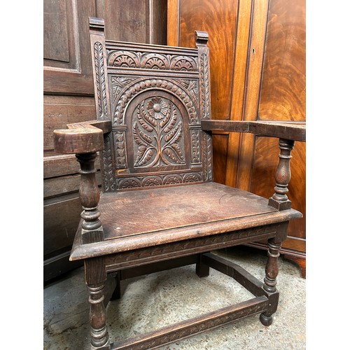 351A - An early 20th Century solid oak Wainscot chair with panelled back carved with a flower design, turne... 