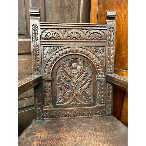 351A - An early 20th Century solid oak Wainscot chair with panelled back carved with a flower design, turne... 