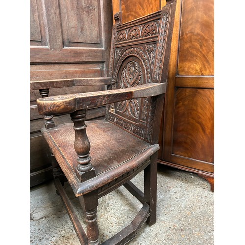 351A - An early 20th Century solid oak Wainscot chair with panelled back carved with a flower design, turne... 