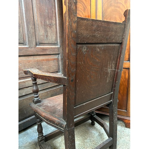 351A - An early 20th Century solid oak Wainscot chair with panelled back carved with a flower design, turne... 