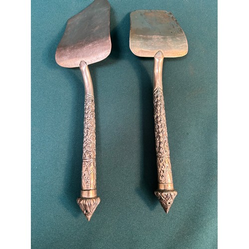 148 - Pair of 20th Century silver metal servers / slices with ornate embossed handles. Probably Thai / Far... 