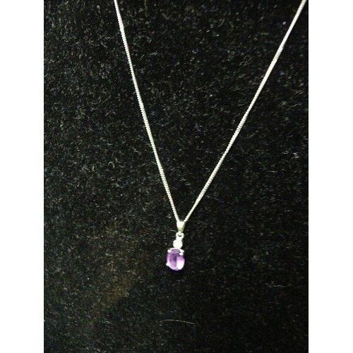 33 - A very pretty 9ct white gold pendant set with an oval cut amethyst with a small diamond above, on a ... 