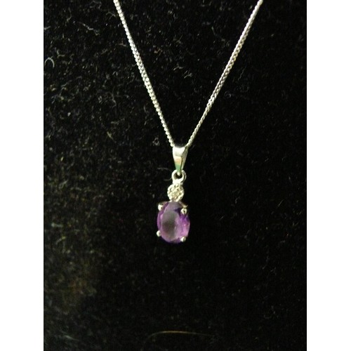 33 - A very pretty 9ct white gold pendant set with an oval cut amethyst with a small diamond above, on a ... 