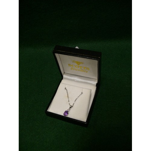 33 - A very pretty 9ct white gold pendant set with an oval cut amethyst with a small diamond above, on a ... 