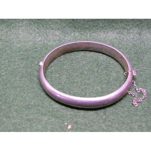 31F - A SILVER BANGLE DECORATED WITH SAFETY CHAIN