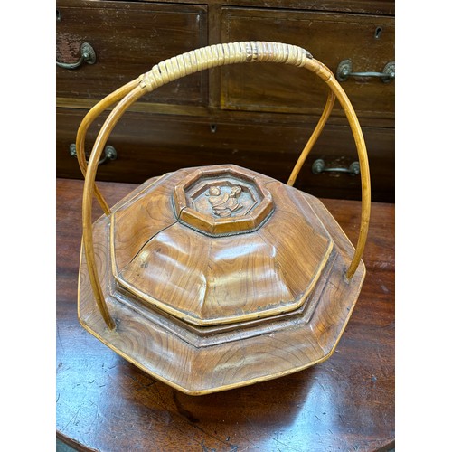 149F - A Chinese hand carved wooden rice basket, with a carving of a boy in the lid, wicker handle - 32cm d... 