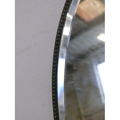 151 - A LARGE OVAL BEVELL EDGED MIRROR