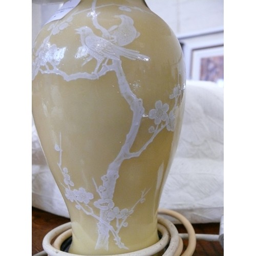 275 - TABLE LAMP WITH MUSTARD COLOUR BASE ADORNED WITH WHITE BIRDS AN A CREAM PLEATED SHADE