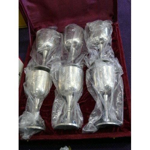 110 - A SET OF DECORATIVE SILVERPLATE GOBLETS IN A FITTED RED VELVET CASE