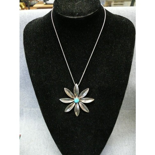 31 - LARGE SILVER METAL DAISY PENDANT WITH TURQUOISE CENTRE ON SILVER HALLMARKED CHAIN