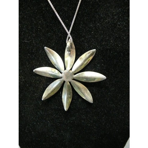 31 - LARGE SILVER METAL DAISY PENDANT WITH TURQUOISE CENTRE ON SILVER HALLMARKED CHAIN