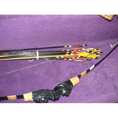 252 - A CARVED WOODEN BOW WITH RED INDIAN AND A SELECTION OF ARROWS