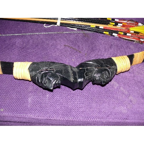 252 - A CARVED WOODEN BOW WITH RED INDIAN AND A SELECTION OF ARROWS