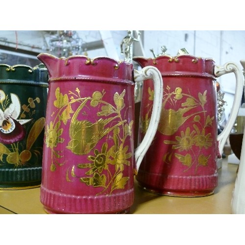 293B - 2 PITCHER JUGS IN CERISE WITH GILT BIRDS